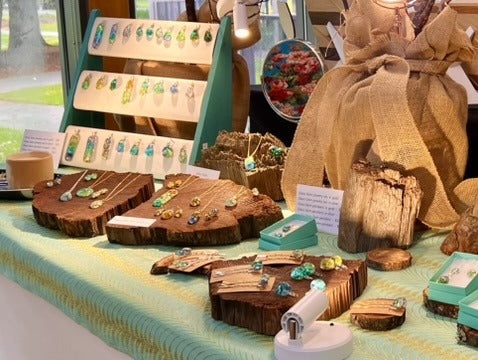Redwood Mountain Arts booth with jewelry displayed on wood slabs