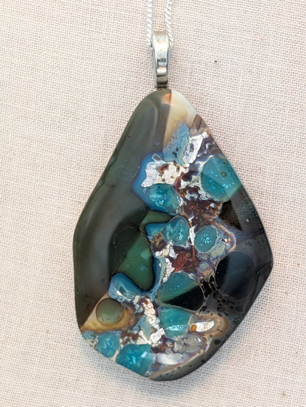 Freeform fused glass pendant in teal and charcoal