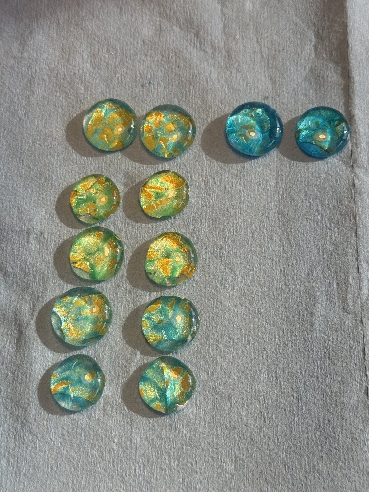 Fired glass gems in gold and teal, after the kiln