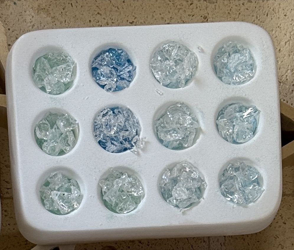 Casting mold filled with crushed clear and blue glass before firing